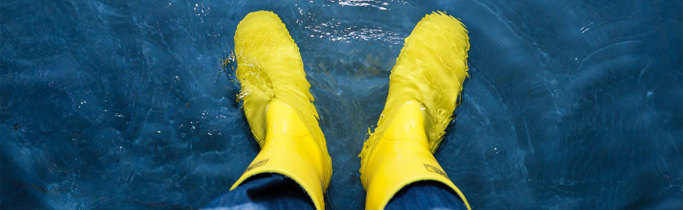 Man Wearing Yellow Boots in Leaky Basement